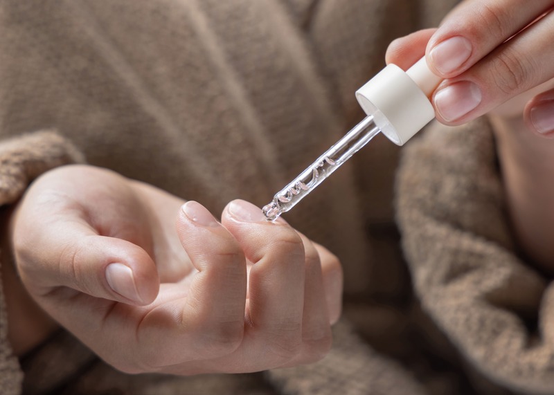 donna mette olio sulle cuticole delle proprie mani