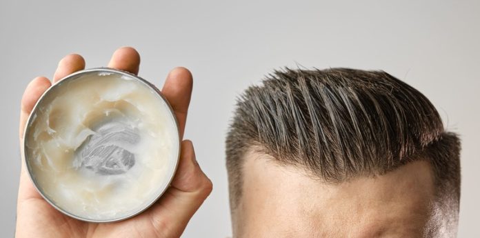 cera per capelli-2-2 uomo tiene in mano cera per capelli